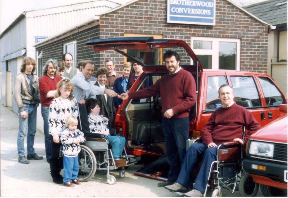 A crowd gathers outside around a WAV vehicle demonstration at an exhibition.  